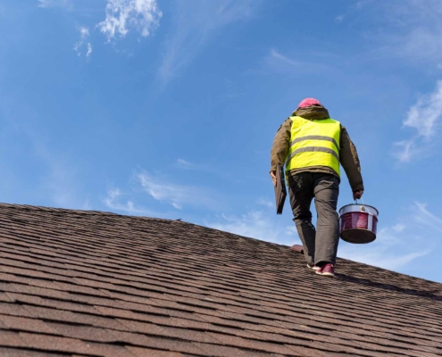 Roofing worker inspecting a rooftop after completion