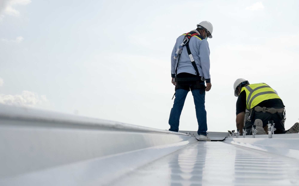 Two roofers on commercial rooftop for inspection