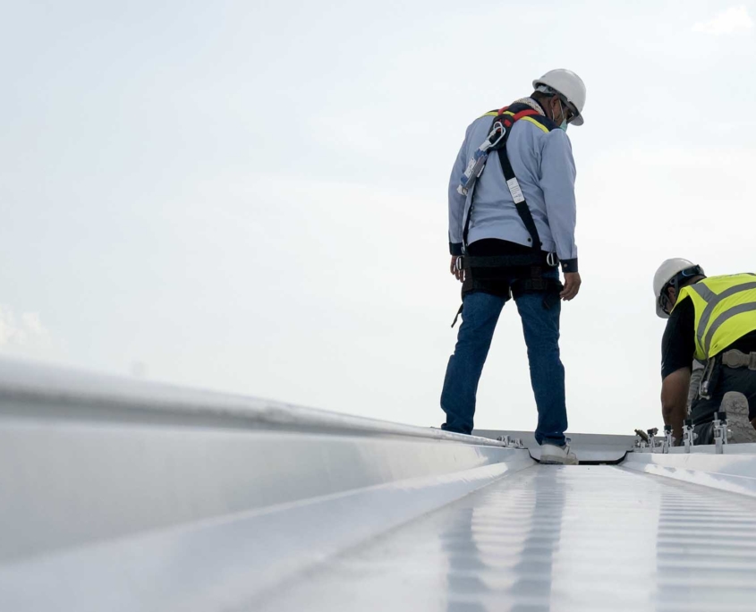 Two roofers on commercial rooftop for inspection