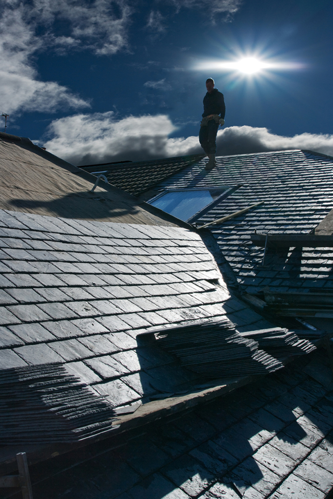 Construction Worker on Roof Applying Slate Tiles