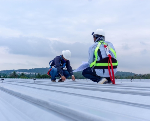 Image of two workers inspecting a commercial roof.
