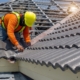 Image of a worker replacing tiles on a residential roof.