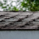Front view of several curling roof shingles